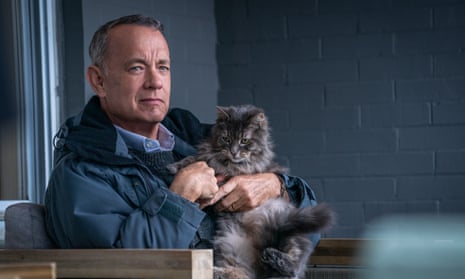 Tom Hanks holding a cat and looking a bit grumpy