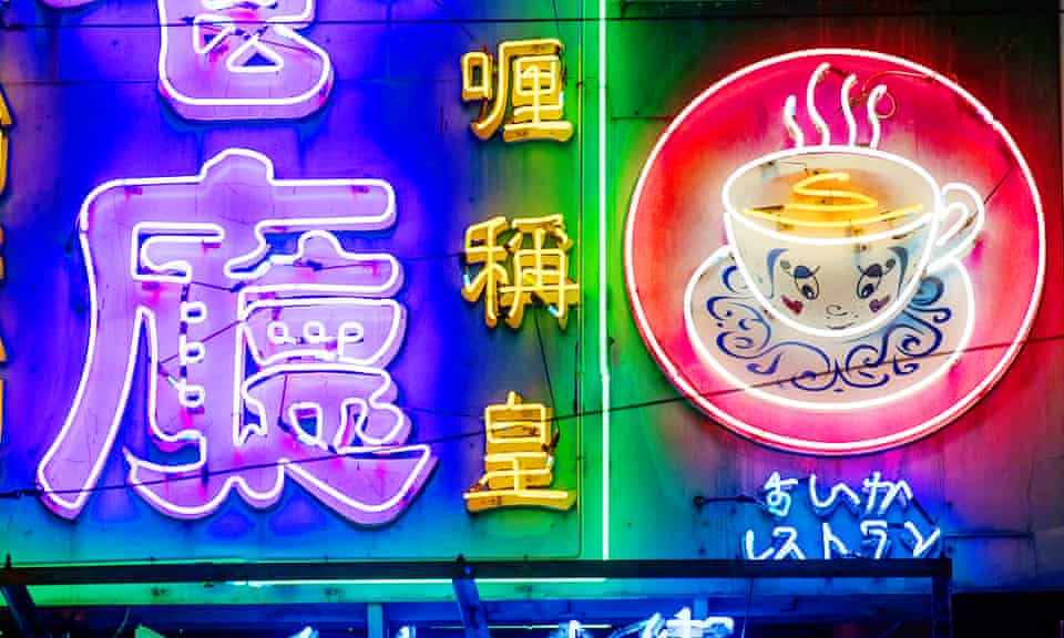 Close up of neon signs in Hong Kong. One shows lettering, the other sign is of steam coming off a tea cup.