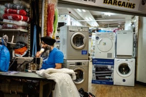 A photograph by Merlin Daleman of a man eating an ice-cream at his work station in Dudley, June 2017. 