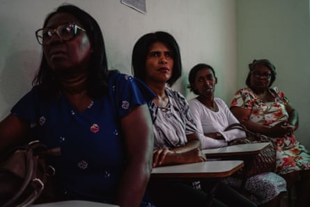 أربعة أشخاص من مجتمع كويلومبولا ينتظرون مقابلة المحامين لمناقشة التقدم المحرز في الدعوى القضائية التي رفعها المتضررون من مأساة ماريانا.