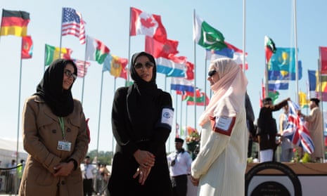 Women attendees in front of flags from many countries at the UK’s largest Muslim convention, Jalsa Salana