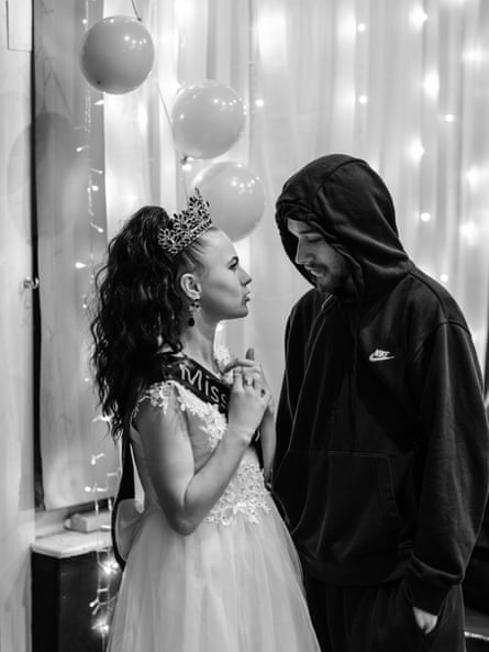 Kayleigh Mott in a tiara looks at a man in a hoodie