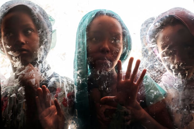 Girls are seen through a glass at the compound of the Agda Hotel, in the city of Semera, Afar region, Ethiopia