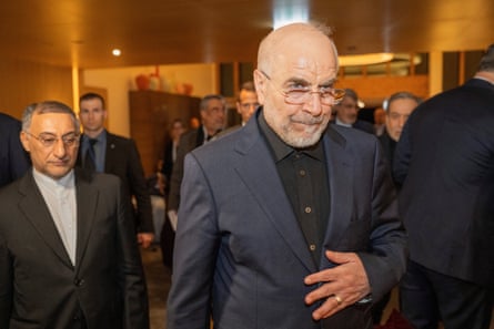 Mohammad Ghalibaf wearing a suit walks towards the camera