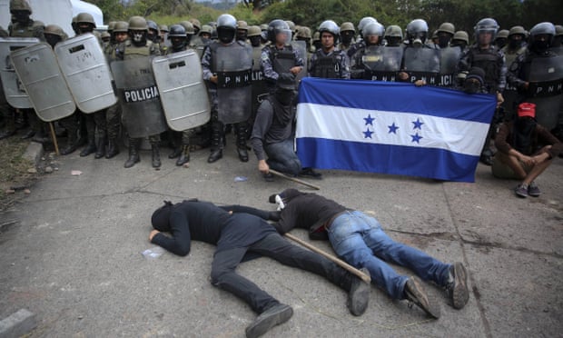 Opposition supporters stage a die-in in front of a police and military checkpoint where they demonstrate, in Tegucigalpa, Honduras, on 22 December 2017.
