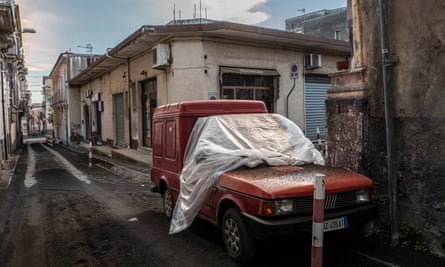 A car covered by the volcanic ash from Etna. Car owners in Giarre have to cover them with plastic sheets to protect them.