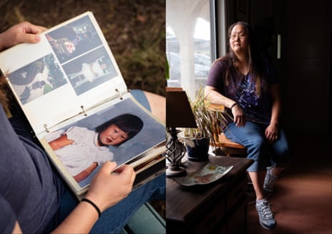 A woman sits at home and looks at a scrapbook of childhood photos