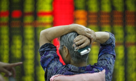 An investor watches market returns at a stock exchange hall on 27 July in Tai an, China.