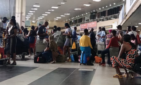 People queue at the entrance to departures in Lagos airport, Nigeria.