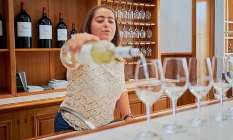 A young female french employee pours wine on the tour at Chateau Lagrange in Saint-Julien in the medoc region of Bordeaux, France August 20192C2JMG8 A young female french employee pours wine on the tour at Chateau Lagrange in Saint-Julien in the medoc region of Bordeaux, France August 2019