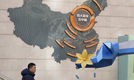 A man passes by a map depicting Evergrande's commercial projects in China at a mall in Beijing, China