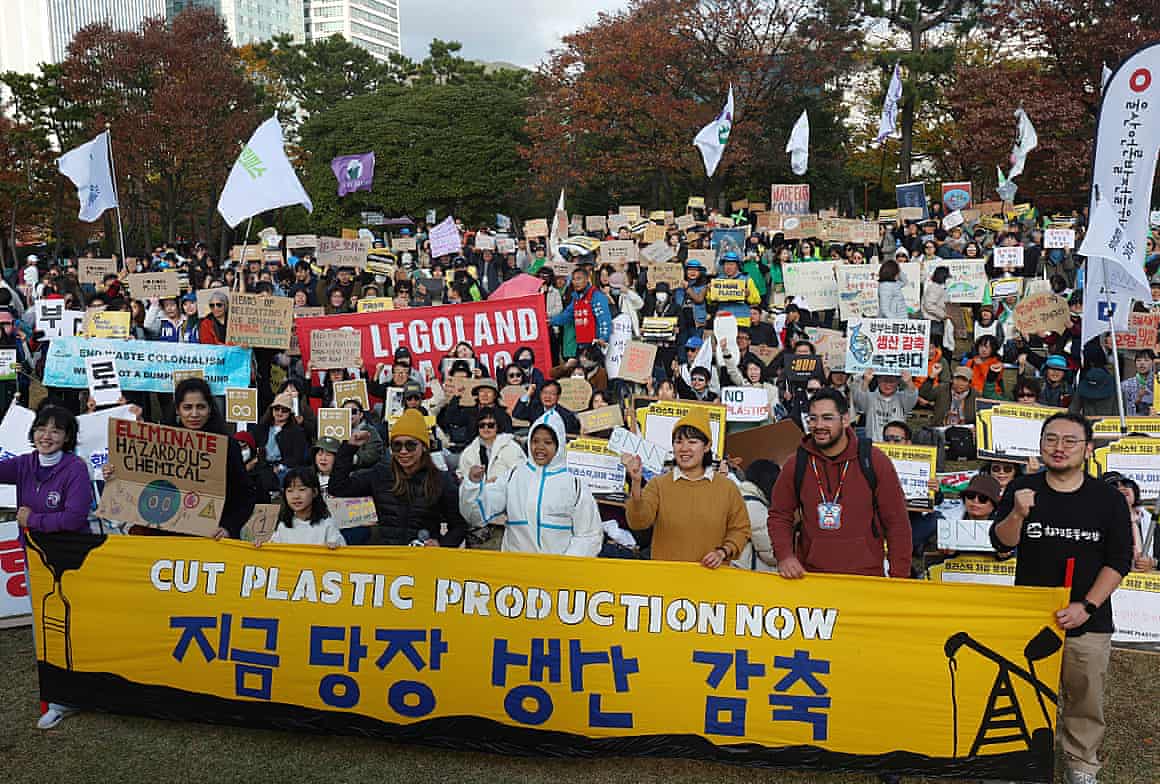Environment activists stage a rally, some holding a banner that says: ‘Cut plastic production now.’