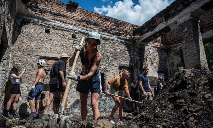 Volunteers remove debris from the House of a Culture in the village of Yahidne, Chernihiv region, which was heavily damaged earlier in the war.