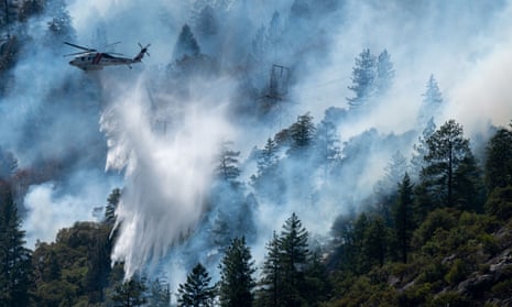 Helicopters drop water to battle the Dixie fire in Plumas county, California.