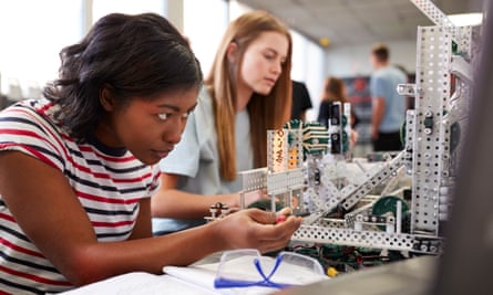 Two Female College Students Building Machine In Science Robotics Or Engineering Class