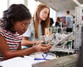 Two Female College Students Building Machine In Science Robotics Or Engineering Class
