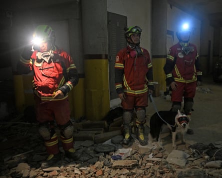 Rescue workers with the dog that helped find Hernán Alberto Gil Flores.
