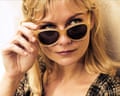 Closeup of Kirsten Dunst looking over the tops of her sunglasses