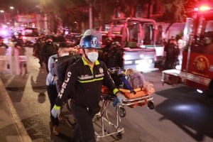 Paramedics wheel an injured person on a stretcher