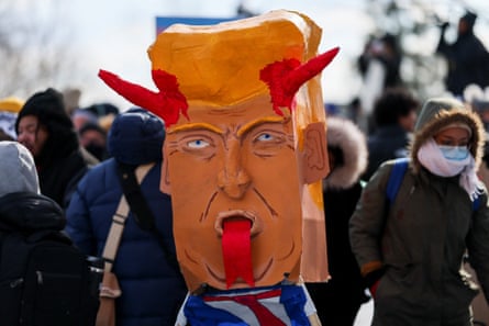 People stand near an effigy resembling Trump