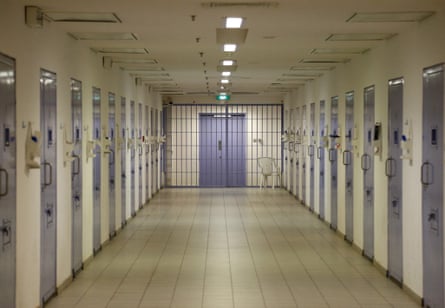 A prison corridor with locked cells on either side