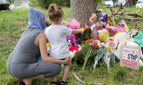 Families pay their respects on 8 June 2021, at a makeshift memorial near the site where a man driving a pickup truck struck and killed four members of a Muslim family in London, Ontario, Canada. 