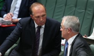 Australian immigration minister Peter Dutton talks to prime minister Malcolm Turnbull in parliament.