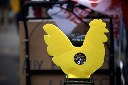 A yellow sign in the shape of a chicken with a sticker in French that translates as ‘Outdoors is dead’.