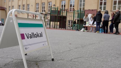 A polling station sign outside Adolf Fredriks Musikklasser in Stockholm, with one of the stalls seen in the background.
