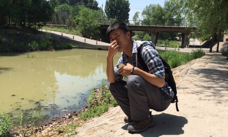 Shi Dianshuo holds his nose on the banks of Beijing’s putrid River of Happiness in northern Beijing.