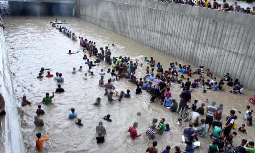 People wading through flood water in Karachi on Thursday.