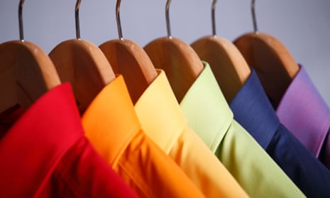 Close-up of rainbow collared shirts on wooden clothes hangers