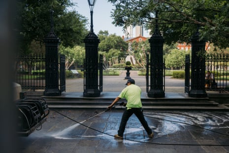 someone power hosing the pavement outside a square