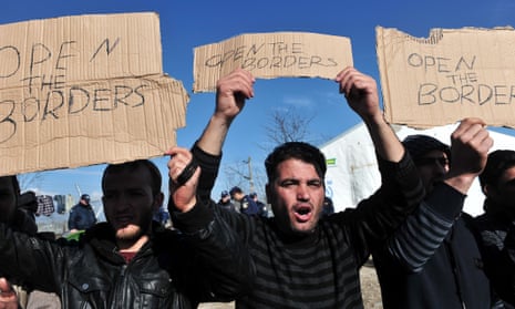 Men hold ‘open the borders’ banners in a protest by the Idomeni crossing from Greece to Macedonia.
