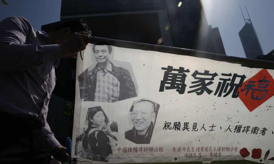 A pro-democracy protester arranges a banner during a rally in Hong Kong on Wednesday. Police have said three of the missing booksellers will be freed on bail soon.
