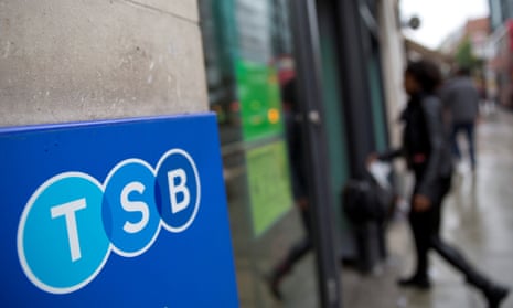 A woman walks into a branch of TSB bank in London