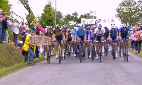 The woman holds up a sign in front of a Tour de France cyclist moments before the crash. 