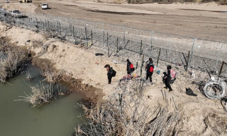 An aerial view of the area as migrants walking along razor wire after crossing the Rio Grande into the US on 28 January 2024 in Eagle Pass, Texas. 