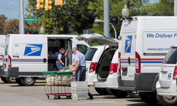 United States Postal Service (USPS) workers load mail into delivery trucks outside a post office in Royal Oak, Michigan, U.S., August 2020.