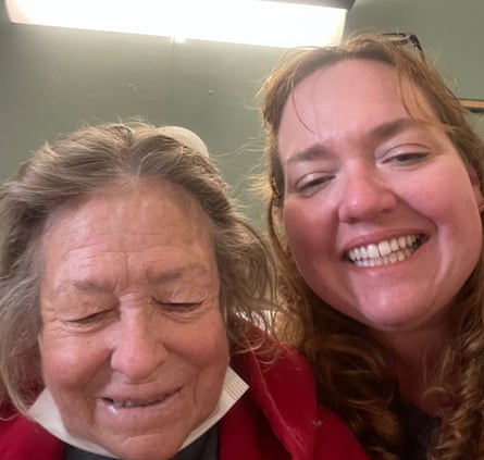 Two white women, one older and one younger, smile for a selfie with a florescent light overhead.