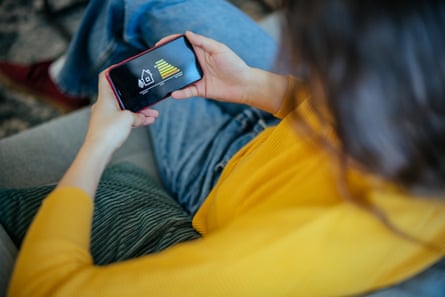Woman uses a mobile phone while sitting on a sofa