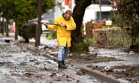 Eli Roth clears mud and debris from a drain outside the Lismore house he bought two years ago