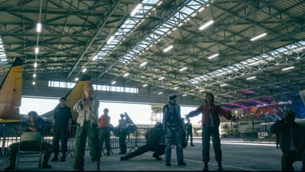 People standing around in a military plane hangar