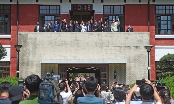 Pelosi and other officials wave to journalists at Taiwan’s parliament on Wednesday.