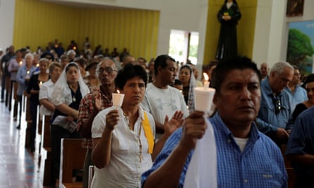 People hold candles during mass at the Metropolitan Cathedral to demand release of detained demonstrators.