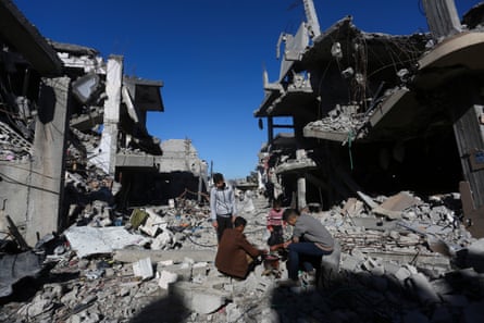 Palestinians cook bread by their destroyed homes in the Gaza Strip during the temporary ceasefire.