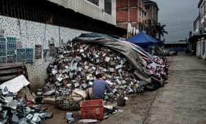 A man sorts through electronic waste at a scrapyard in Guiyu, China