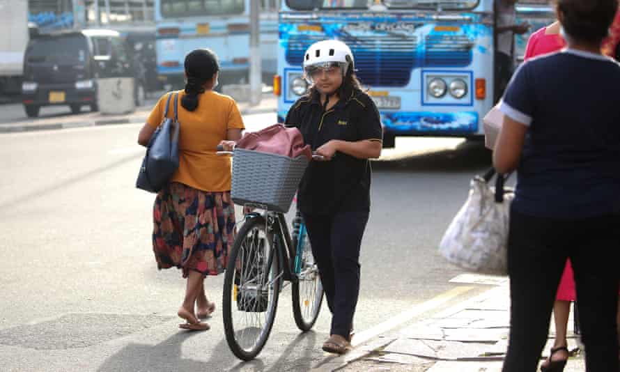 A woman returns from work on her bicycle in Colombo amid Sri Lanka’s fuel and economic crisis.