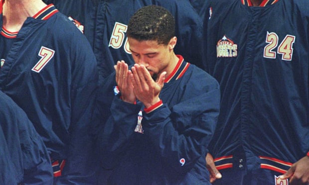 Mahmoud Abdul-Rauf stands in prayer during the singing of the Star-Spangled banner in 1996