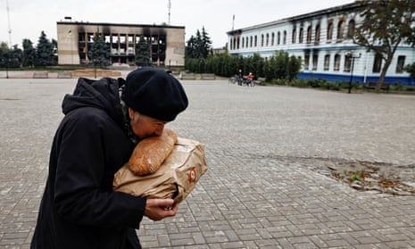 A local resident kisses bread after she received humanitarian aid in the recently liberated town of Izium in the Kharkiv region.